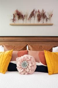 una cama con almohadas y una flor rosa en ella en 'Mountain Serenity' A Luxury Downtown Condo with Mountain Views at Arras Vacation Rentals, en Asheville
