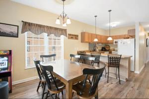 a kitchen and dining room with a table and chairs at Bandit's Riverfront Retreat - Mountain View- Condo-Fishing-Balcony-Fireplace-Great Location! in Pigeon Forge