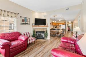 a living room with red furniture and a fireplace at Bandit's Riverfront Retreat - Mountain View- Condo-Fishing-Balcony-Fireplace-Great Location! in Pigeon Forge