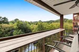 a balcony with chairs and a view of the woods at Bandit's Riverfront Retreat - Mountain View- Condo-Fishing-Balcony-Fireplace-Great Location! in Pigeon Forge