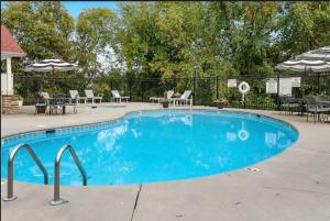 a large blue swimming pool with chairs and umbrellas at Bandit's Riverfront Retreat - Mountain View- Condo-Fishing-Balcony-Fireplace-Great Location! in Pigeon Forge