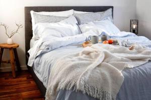 a bed with a blanket and a bowl of fruit on it at Shack on the Bay - A Lovely Bayside Cabin in Strahan