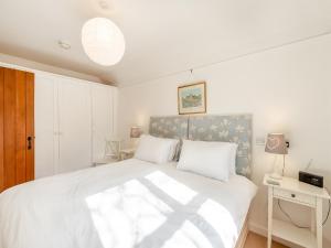 a bedroom with a large white bed with white sheets at Snaylam House Cottage in Rye