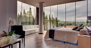 a bedroom with a white bed and a large window at Hotel Las Terrazas & Suite in Albolote