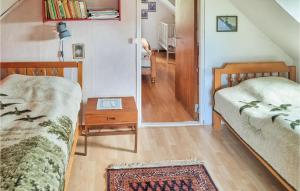 a small room with two beds and a table at Lovely Home In Degerhamn With Kitchen in Degerhamn