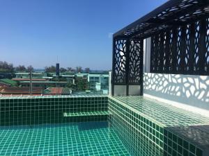 a swimming pool with green tiles on the roof of a building at I AM O'TEL Patong in Patong Beach