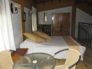 1 dormitorio con 1 cama con mesa de cristal y sillas en Cabañas Los Arreboles en Potrerillos