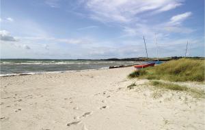a beach with a boat on the sand and the ocean at Holiday Home H in Højby +19 photos