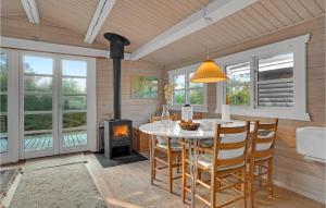 a dining room with a table and a wood stove at Holiday Home H in Højby