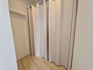 Pokój z białymi zasłonami i drzwiami w obiekcie Studio Confort pour 4 pers. proche Plage/Commerces - Châtelaillon-Plage - FR-1-706-1 w mieście Châtelaillon-Plage