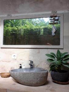 Villa Sea La Vie Private pool في غيلي مينو: حمام مع حوض حجري ومصنع خزاف