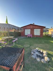 um quintal com um grelhador e uma mesa de piquenique e uma casa em cabaña 2 vista campana em Hijuelas