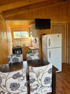 uma cozinha com um frigorífico branco num quarto em cabaña 2 vista campana em Hijuelas