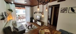 Hospedagem Doce Lar - Casa Bougainville في تيريسوبوليس: غرفة معيشة مع أريكة وتلفزيون