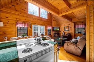 a kitchen and living room with a stove in a cabin at Great Smoky Mountains Cabin!, Secluded, Pet-Kid Friendly! in Sevierville