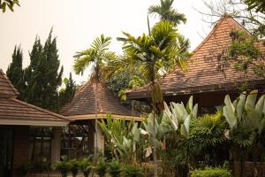 een huis met twee daken en palmbomen bij ANANTAYA CHIANGMAI BOUTIQUE HOTEL in Chiang Mai