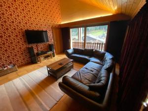 a living room with a leather couch and a television at Duplex 4 étoiles pour 20 pers. près des pistes à La Chapelle-d'Abondance - FR-1-693-95 in La Chapelle-dʼAbondance