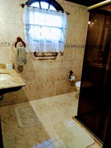 a bathroom with a shower with a sink and a toilet at Hospedagem Doce Lar - Casa Bougainville in Teresópolis