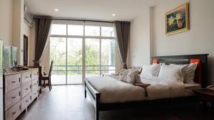 ANANTAYA CHIANGMAI BOUTIQUE HOTEL في شيانغ ماي: غرفة نوم بسرير ونافذة كبيرة
