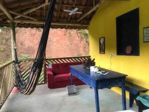 a living room with a red couch and a hammock at Refúgio, Aconchego, Aonde nasce o sol e Cachoeira! in Mercês