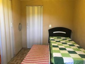 a bedroom with a bed and a rug next to a door at Refúgio, Aconchego, Aonde nasce o sol e Cachoeira! in Mercês