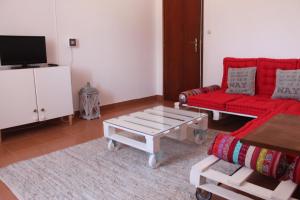 a living room with a red couch and a coffee table at Vale do Boto-Quinta com 3 casas in Castro Marim