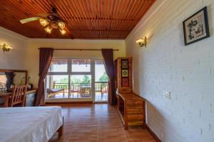 1 dormitorio con 1 cama y ventilador de techo en Mango Beach Resort, en Phu Quoc