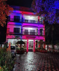 un edificio con luces púrpuras en la parte delantera en Private Room! Alleppey Villa!, en Alleppey