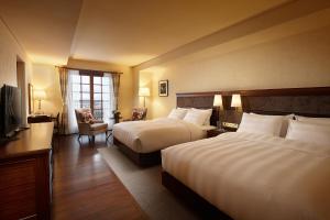 a hotel room with two beds and a television at Lotte Arai Resort in Myoko