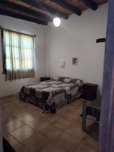 1 dormitorio con cama y ventana. en El Espinillo, Casa de Campo en Santa Rosa de Calamuchita