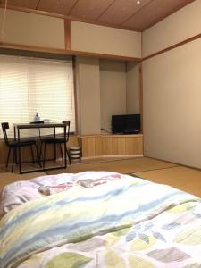 野迫川村にある民宿かわらび荘のベッドルーム1室(ベッド1台、テーブル、テーブル、テレビ付)