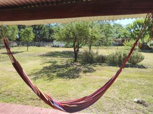 a hammock hanging from a porch in a yard at El Espinillo, Casa de Campo in Santa Rosa de Calamuchita