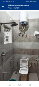 a bathroom with a white toilet in a stall at Presidency address apartments in Bengaluru