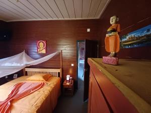 Principe的住宿－Pousadinha Mar Ave Ilha，卧室,配有一张床和一个女人的雕像