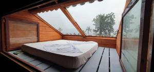 Cama en habitación con ventana grande en Pousadinha Mar Ave Ilha en Principe