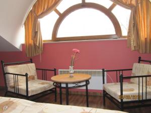 een kamer met 2 stoelen, een tafel en een raam bij Central Family Hotel in Haskovo