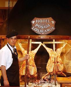 a man standing in front of a table filled with food at Hotel Posada Los Alamos in El Calafate