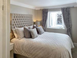 Un dormitorio con una cama blanca con almohadas y una ventana en The White House Retreat, en Findon