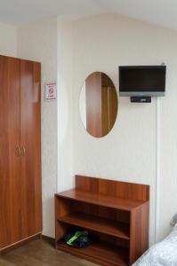 Cette chambre comprend une télévision murale et un miroir. dans l'établissement Baker Street Hotel, à Nijni Novgorod
