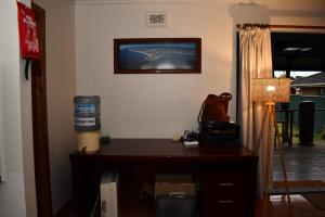 um quarto com uma secretária e uma televisão na parede em Wollongong Beach House Living em Gwynneville