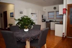 uma mesa de jantar com cadeiras e uma planta em Wollongong Beach House Living em Gwynneville