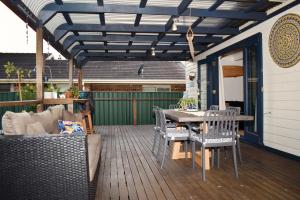 um pátio com uma mesa e cadeiras num deque em Wollongong Beach House Living em Gwynneville