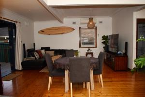 - un salon avec une table, des chaises et un canapé dans l'établissement Wollongong Beach House Living, à Gwynneville