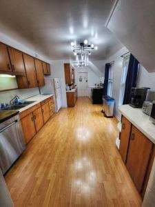 una cucina con pavimento in legno massello e una cucina con frigorifero. di The Maple Shade Suite a Sussex