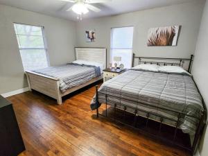 sypialnia z 2 łóżkami i drewnianą podłogą w obiekcie Cozy Corner w mieście Denison