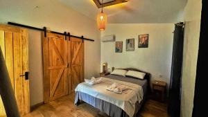 um quarto com uma cama e uma porta de madeira em AA Jungle Guesthouse em San Juan