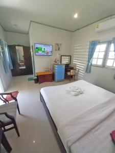 um quarto com uma grande cama branca e uma sala de estar em Dusita Parkview Resort @ Khua Suan Pla em Ban Na Khwai