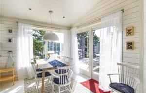 uma sala de jantar com uma mesa e cadeiras e uma janela em Awesome Home In Mellerud With Sauna, Wifi And Jacuzzi em Mellerud