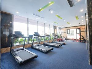 a gym with rows of treadmills and elliptical machines at Canary Gold Hotel Quy Nhơn - Beachfront - Iconic Location in Quy Nhon +103 photos