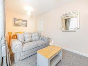 a living room with a couch and a table at Maceys Cottage - Uk42146 in North Somercotes